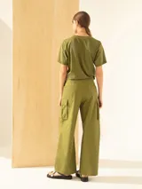 Pantalón cargo verde oliva de algodón, con corte ancho, bolsillos laterales con tapa y cierre, y tablones a la altura de las rodillas.