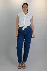 Pantalón jean de corte mom y color azul oscuro, con tiro alto y diseño recto ligeramente ajustado en los tobillos.