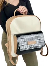 Mochila grande de cuero color beige, blanco y negro charol. Tiene un bolsillo frontal con cierre de broche imantado y logo grabado.