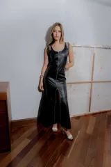 Vestido largo negro de cuero ovino con cierre frontal de cremallera metálica, sin mangas y con tajo lateral.