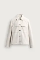Sobrecamisa regular fit de hombre confeccionada en tejido efecto ante de color verde oscuro, con cuello solapa, cierre frontal de botones, bolsillos de plastrón con solapa en el pecho y bolsillos de vivo en la cadera.