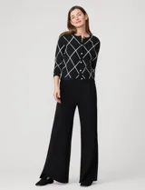 Cardigan tejido negro con estampado de rombos blancos, cuello redondo y cierre frontal con botones dorados. Marca Cable & Gauge.