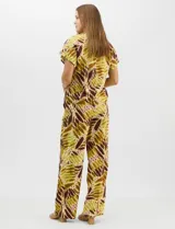 Conjunto de dos piezas confeccionado en mezcla de algodón y lino, con estampado abstracto en tonos verde y borravino. Incluye una blusa de manga corta con escote en V y cierre frontal con un botón, y un pantalón de tiro alto y pierna recta con bolsillos laterales.
