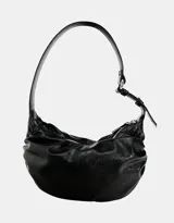 Bolso tipo hobo de cuero sintético negro, con efecto arrugado o fruncido en la parte superior y cierre de cremallera plateada. Posee una correa de hombro ajustable.
