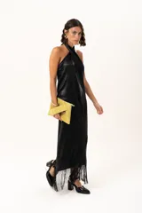 Vestido midi de satén color negro, con escote halter cruzado y ruedo terminado en flecos largos.