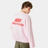 Remera de manga larga color rosa, con corte boxy fit y estampado gráfico de la marca Eme Studios en color rojo en el centro del pecho.