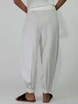 Pantalon negro de viscosa con pinzas en la cintura, bolsillos laterales y botamangas ajustadas.