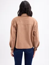 Chaqueta de gamuza sintética color negro, con cuello camisero, bolsillos frontales con solapa, cierre de botones y mangas largas.