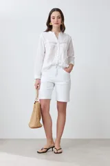 Camisa blanca de manga larga con bordados en el frente y cuello.