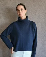 Sweater color crudo de cuello alto con mangas largas y corte holgado.