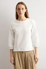 Remera bordó de manga larga con detalles en popelina en las mangas y costuras visibles en contraste.