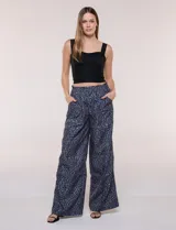 Pantalón wide leg de tiro medio con estampado animal print en tonos grises y negros, de corte holgado y bolsillos laterales. Cuenta con pretina elástica en la parte trasera y bolsillos delanteros aplicados.
