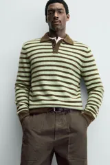 Polo de punto de manga larga con diseño de rayas horizontales en tonos verde y marrón. Presenta cuello solapa, cierre frontal con botonadura y acabados en rib en puños y ruedo.