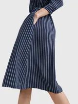 Vestido camisero midi azul marino con rayas verticales blancas, cuello camisero, cierre frontal con botones, mangas largas con puños abotonados y cinturón de lazo a juego.