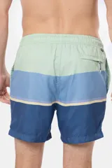Short de baño con diseño de bloques de color y franjas horizontales en tonos azules y celestes, con cintura elastizada.