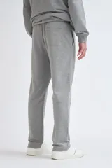 Pantalón deportivo de corte recto en color gris melange, con cintura elástica y cordón ajustable.
