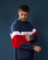 Buzo de felpa azul marino, rojo y blanco con diseño de bloques de color.