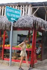 Vestido corto de tejido de punto color beige, con escote profundo tipo halter y falda con volados en el frente.