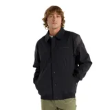 Campera negra de New Balance, modelo Athletics Varsit, con cierre frontal a presión, mangas largas con detalle de color en los hombros, bolsillos delanteros y bolsillo interior con cremallera.