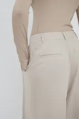 Pantalón de corte ancho (relaxed fit) color gris claro, con pinzas frontales y efecto lavado sedoso.