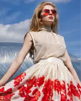 Falda midi de seda natural color crema con estampado floral en tonos rojo y dorado.