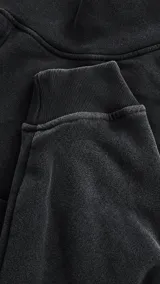 Buzo de cuello alto con efecto de lavado stone wash, confeccionado en algodón con costuras verticales decorativas y logo estampado en el pecho.