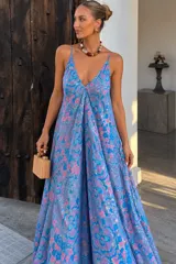 Vestido largo de rayón con estampado floral en tonos azules y rosados, de corte solera con escote en V y tirantes finos.