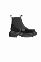Botas tipo chelsea de cuero negro con textura granulada, paneles laterales elásticos y suela track robusta de goma.