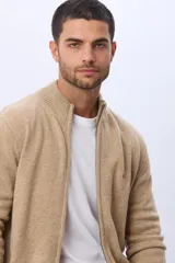 Campera tejida de lana color azul marino, con cuello alto, cierre metálico frontal y bolsillos laterales. Presenta detalles en cuero y logo bordado.