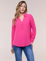 Blusa verde de calce holgado y caída fluida, confeccionada en tejido tipo crepé. Cuenta con cuello camisero con solapa, escote en V y cierre parcial al frente con tres botones metálicos. Las mangas son largas con puños abotonados.