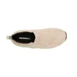 Zapatillas tipo slip-on Merrell modelo Jungle Moc, confeccionadas en gamuza color beige con detalles en verde claro y suela de goma marrón. Presentan diseño sin cordones con paneles elásticos laterales para facilitar el calce y tecnología Air Cushion en el talón para mayor amortiguación.