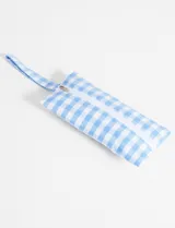 Monedero rectangular de poliéster con estampado de cuadrillé celeste y blanco, cierre superior con cremallera y tira de agarre lateral.