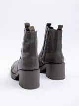 Bota de caña corta color negro, de símil cuero, con plataforma de 7 cm de alto. Cuenta con cierre y pieza de textura croco en laterales.