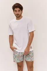 Short de baño celeste con estampa tropical de hojas, animales y flores. Cuenta con cintura elastizada con cordón ajustable y etiqueta textil decorativa en el lateral.