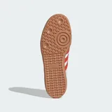 Championes Adidas modelo Samba OG, fabricados en cuero blanco con las icónicas tres tiras y detalles en rojo solar, puntera de nobuk gris claro y suela de goma marrón.