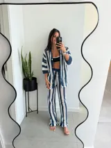 Conjunto de dos piezas tejido a crochet con diseño de rayas verticales en azul y blanco. Incluye una camisa de manga corta con cierre frontal de botones y un pantalón de corte recto y tiro alto con cintura elástica.