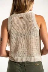 Chaleco tejido sin mangas de calce al cuerpo, con cuello redondo y diseño de punto abierto. Presenta terminaciones acanaladas en cuello, sisas y ruedo.