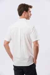 Camisa sport blanca de manga corta, con cuello abotonado, cierre frontal de botones y bolsillo ojal en el pecho.