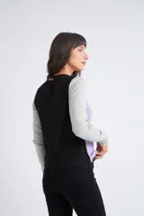 Remera de manga larga con diseño color block, combinando panel frontal en color lila, mangas en gris melange y espalda en negro. Presenta cuello redondo y costuras a la vista.