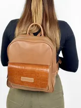 Mochila grande de cuero marrón con bolsillo frontal con textura de cocodrilo y cierre superior con cremallera.