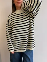 Sweater tejido de punto con diseño a rayas horizontales, cuello redondo y mangas largas con caída holgada.