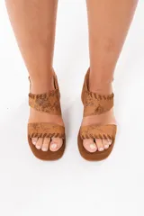 Sandalia de taco chino y plataforma forrada, confeccionada 100% en cuero color tostado con acabado metalizado texturizado en la capellada y detalles de costuras artesanales. Cuenta con doble tira superior y tira trasera ajustable con hebilla metálica.