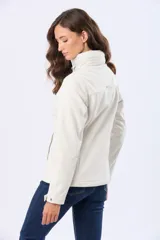 Campera de neopreno en color blanco hueso, con cierre frontal y botones a presión. Presenta cuello alto, mangas largas y bolsillos laterales. Diseño funcional y versátil para uso diario.