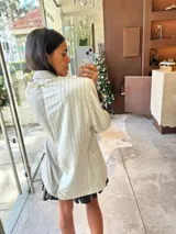Blazer oversize bicolor de la marca Agnés, con diseño de doble faz que combina un lado en tejido gris oscuro liso y otro lado en tejido tostado con patrón de rayas diplomáticas. Cuenta con solapas clásicas, cierre frontal de dos botones y bolsillos aplicados.