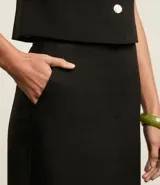 Pollera lápiz midi de tejido plano con corte sastre, color negro. Presenta traspase en la cintura y pences en la parte trasera. Confeccionada en poliéster y elastano.