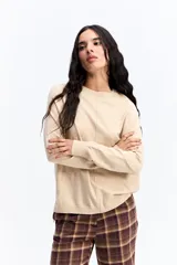 Sweater de punto negro con cuello redondo, manga larga y calce relajado. Presenta una costura vertical central en el frente y puños acanalados.