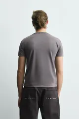 Camiseta de cuello redondo y manga corta con efecto lavado. Presenta una estampa frontal con el texto 'NOIR ECHO' en un tono más oscuro que la prenda.