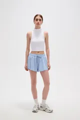 Short de poliéster color celeste, de calce holgado y tiro alto, con cintura elástica ajustable mediante cordón y bolsillos laterales.
