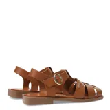 Sandalias franciscanas de cuero color marrón, con diseño de tiras cruzadas, punta cerrada y suela plana. Cuentan con cierre de hebilla metálica ajustable en el tobillo y detalle de aplique metálico con el logo de la marca.