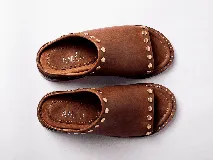 Sandalias de cuero color marrón con detalles de tachas doradas.